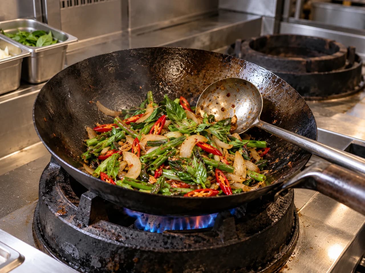 Thai basil vegetables cooking in a seasoned wok on a kitchen burner